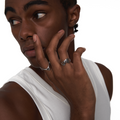 Model wearing curved open silver ring on index finger, styled with a sleeveless white top