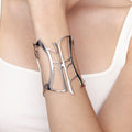 Model wearing sculptural silver cuff bracelet with architectural corset silhouette