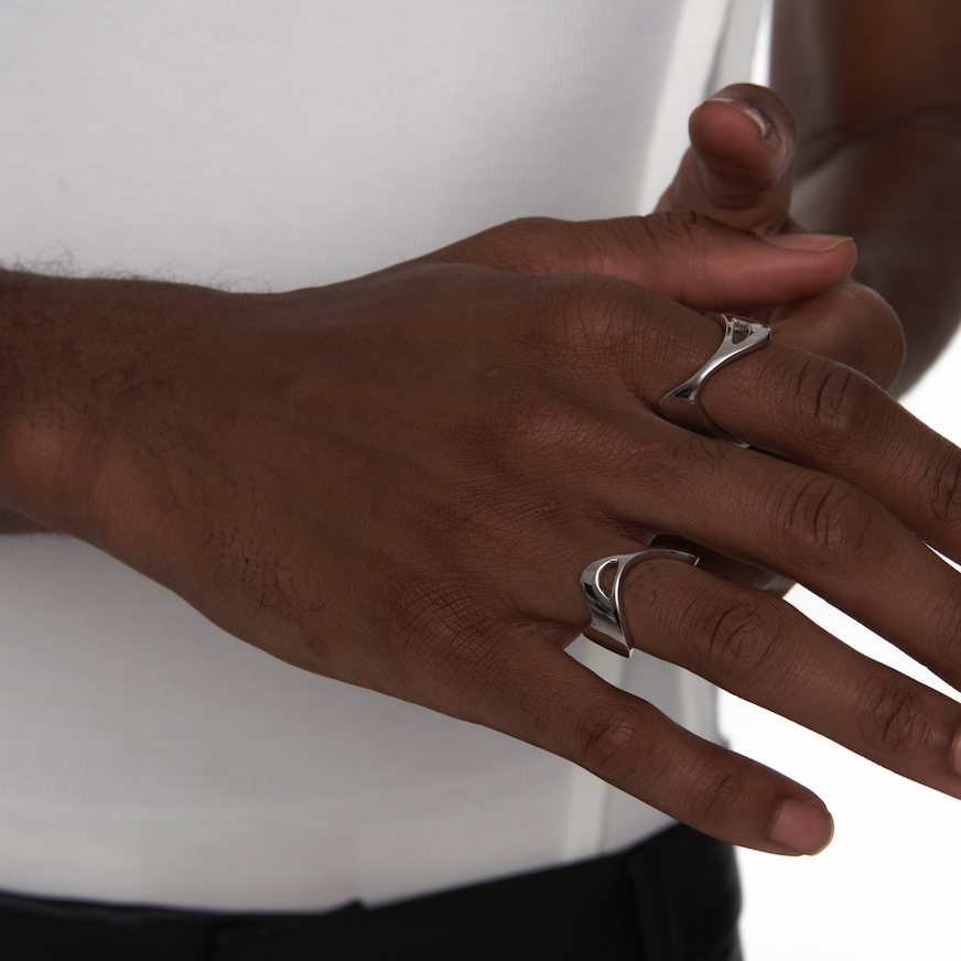 Close-up of hands wearing the Sharp Curve Ring in silver, styled on a male model for a sleek and minimal cyberpunk look.