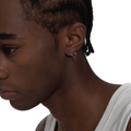 Unisex silver spike earring worn by male model, showcasing futuristic angular design