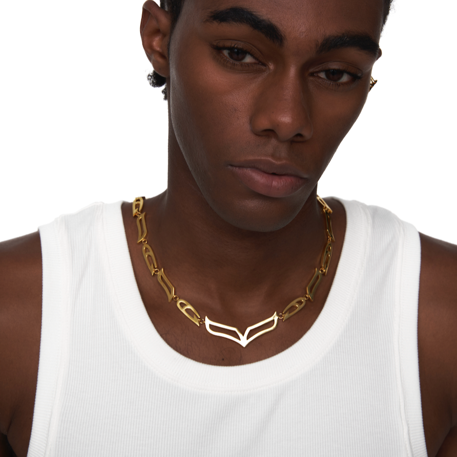 Male model wearing My Heart Soars gold-plated V-link necklace crafted in 925 sterling silver, styled with a white tank for a bold genderless look