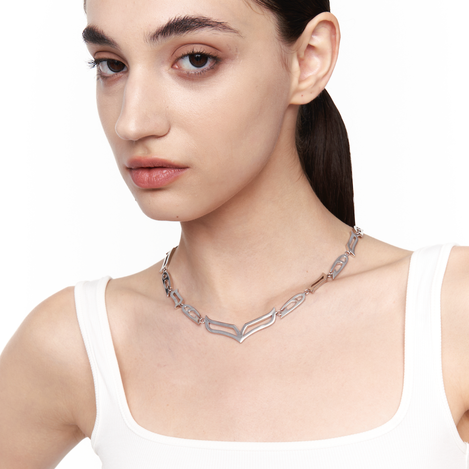 Model wearing My Heart Soars chunky V-link necklace in 925 sterling silver, styled above the collarbone for a minimalist futuristic look