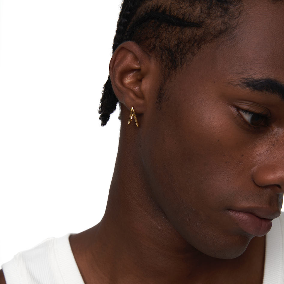 Close-up of model wearing Neural Link gold sculptural earring on left ear
