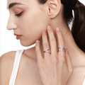 Woman wearing two stackable silver rings with sculptural designs.








