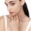 Model showcasing stacked minimalist silver rings in organic V and arc shapes, styled with slicked-back hair and white tank for a futuristic, clean aesthetic
