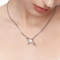 Futuristic silver star necklace worn on neck, featuring a sharp-edged design.
